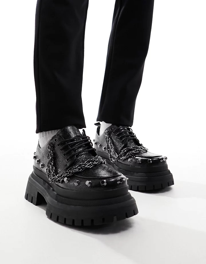 Zapatos negros con suela gruesa, cordones y detalles pl