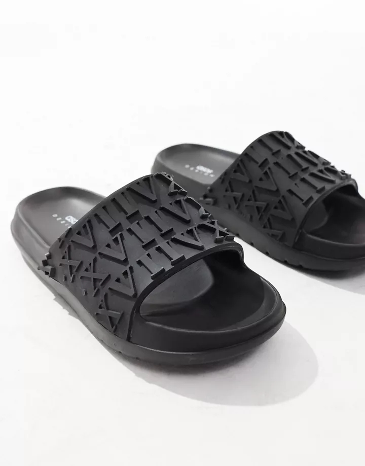 Sandalias negras con diseño de números romanos en relie